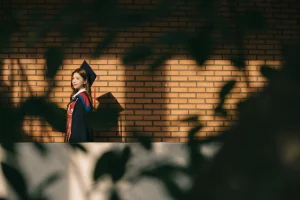 Chân dung nữ sinh mặc áo cử nhân trong ánh nắng và bóng cây
