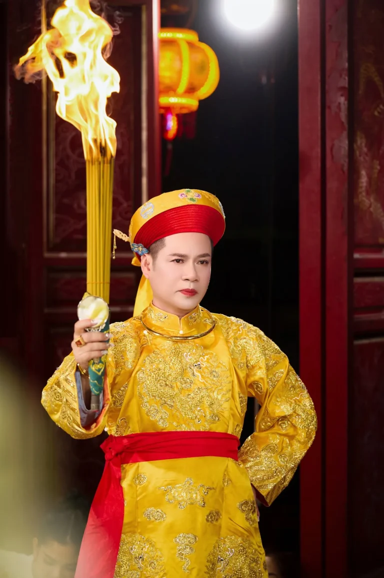 Ảnh hầu đồng với trang phục vàng và đạo cụ hành lễ