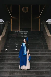 Nữ sinh mặc áo dài xanh đứng tại cầu thang
