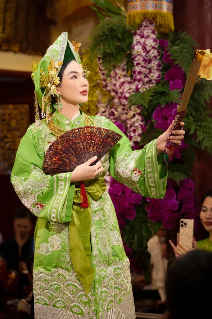 Chân dung hầu đồng với trang phục xanh và quạt hoa