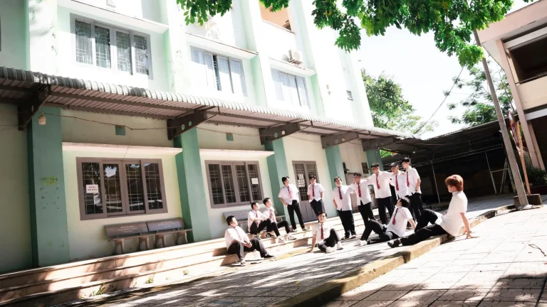 Nhóm học sinh tương tác tại hành lang trường dưới ánh nắng