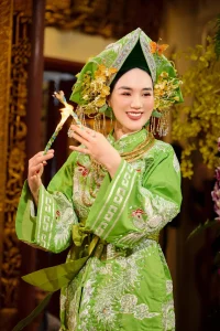 Chân dung hầu đồng trong trang phục xanh và phụ kiện hoa