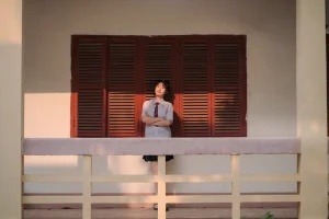 Chân dung đồng phục bên lan can và cửa gỗ trong nắng chiều