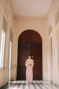 Chân dung áo dài hồng bên khung cửa vòm cổ điển