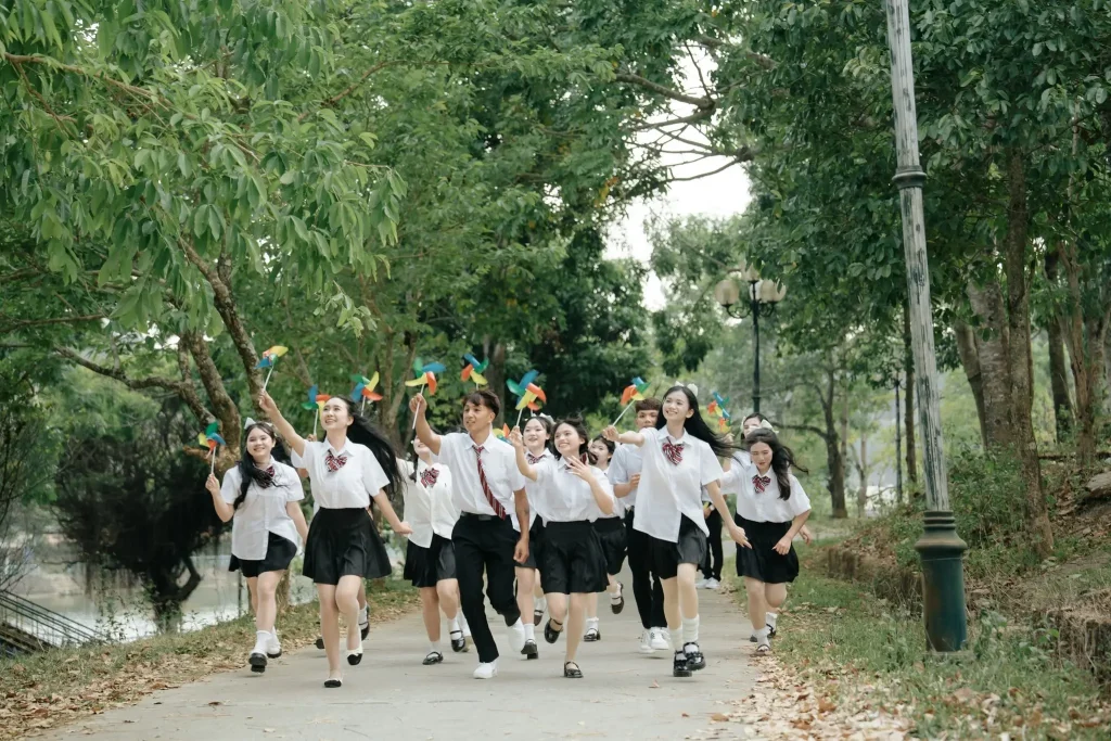 Nhóm học sinh cùng giơ chong chóng trên lối cây