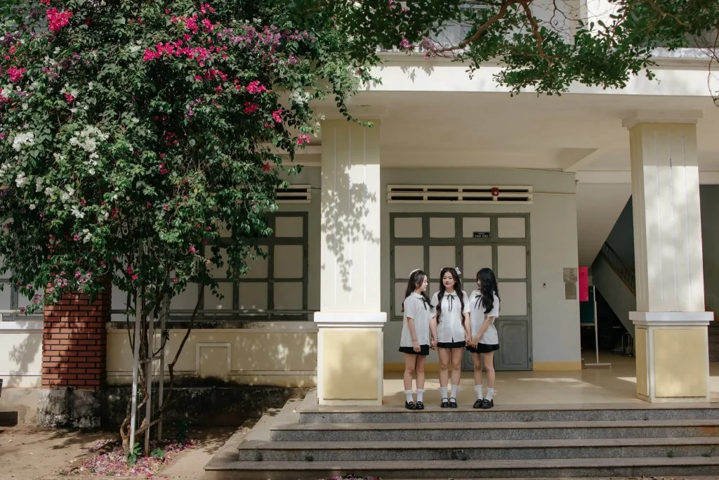 Nhóm học sinh đứng trước cửa nhà có giàn hoa