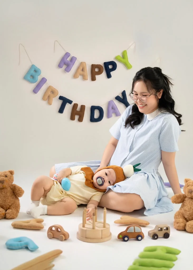 Bé nằm trong vòng tay mẹ ở bối cảnh sinh nhật