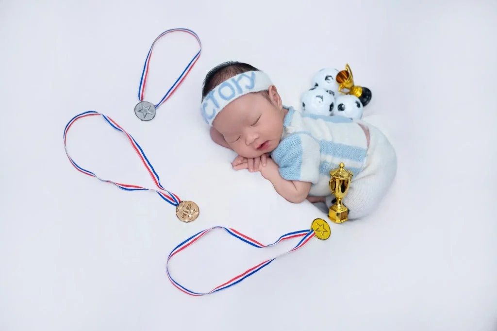 Chụp ảnh bé sơ sinh và bé chưa biết ngồi: phân biệt trước khi chọn tư thế 2 Ảnh newborn: bé nằm ngủ với đạo cụ thể thao