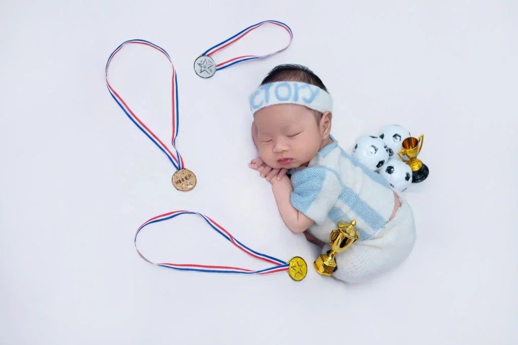 Chụp ảnh bé sơ sinh và bé chưa biết ngồi: phân biệt trước khi chọn tư thế 3 Ảnh newborn: bé nằm ngủ với đạo cụ thể thao