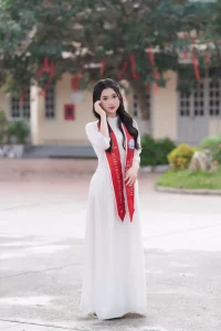 Áo dài và vest, một ngày mình lớn – Concept kỷ yếu thanh lịch 5 Chân dung áo dài trắng và dải đeo đỏ trước sân trường