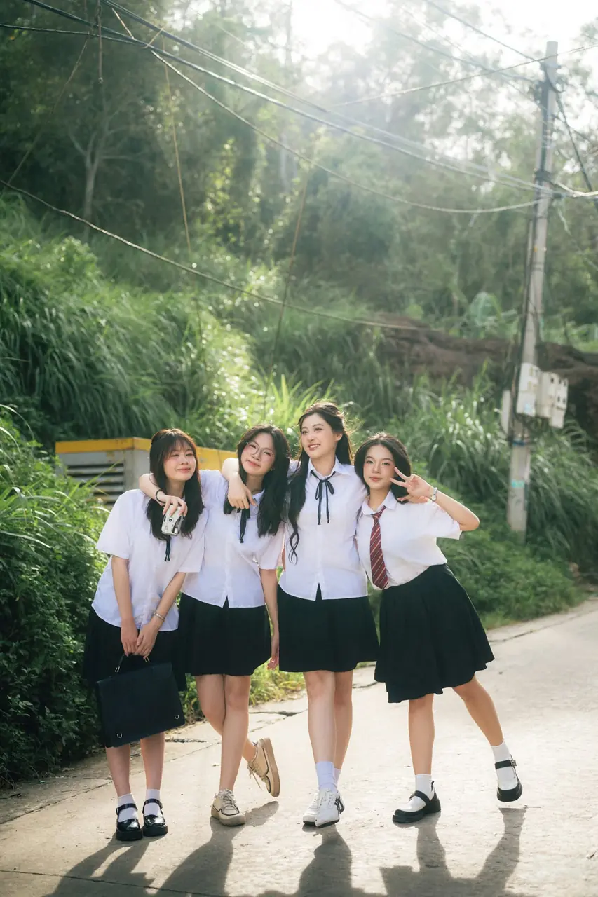 Ba nữ sinh đi bộ trên lối cây xanh