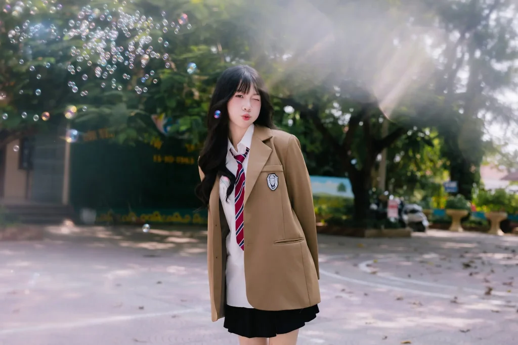 Bạn nữ mặc blazer nâu bên dãy lớp học trong ánh sáng ngược
