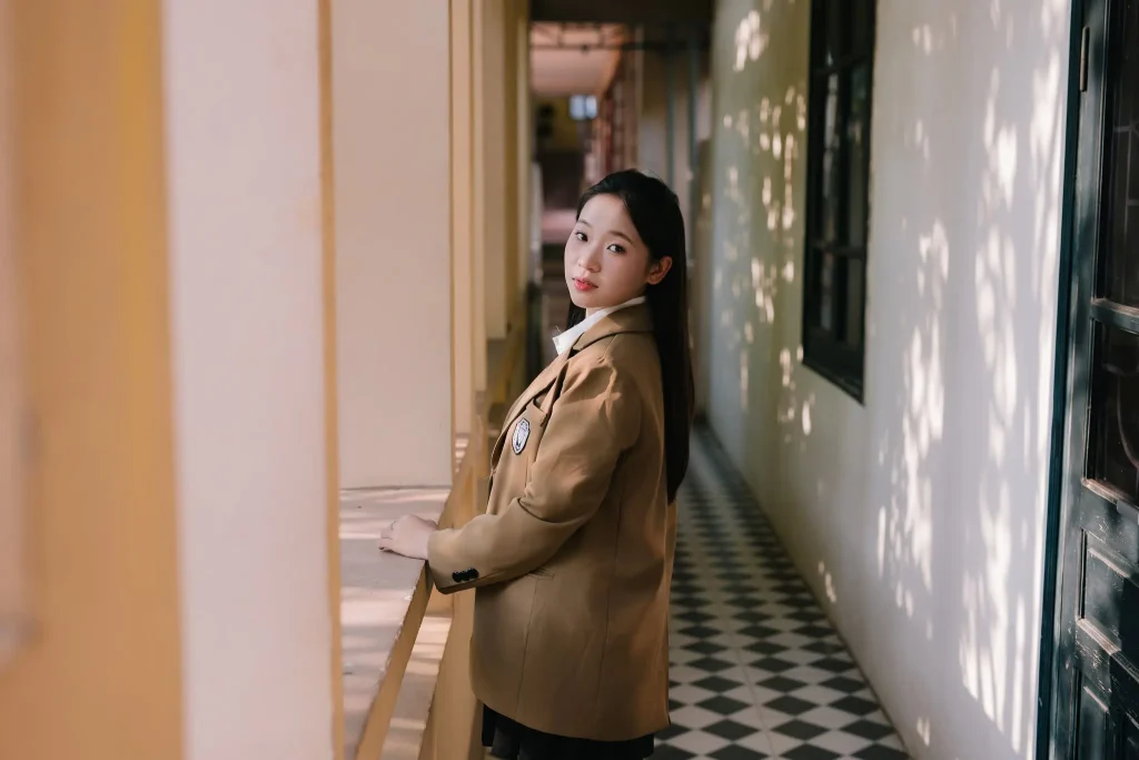Bạn nữ mặc blazer nâu tựa ở hành lang