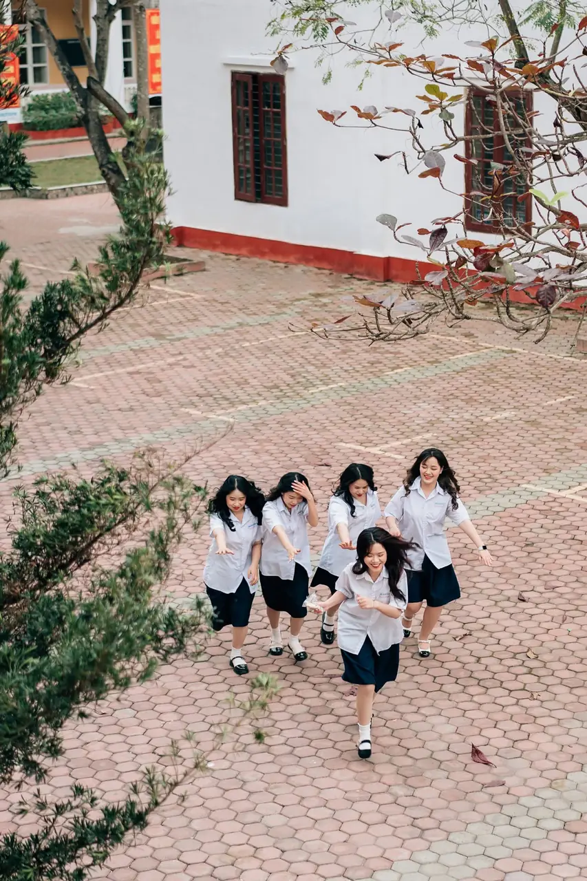 Bốn nữ sinh đi qua sân gạch nhìn từ trên cao