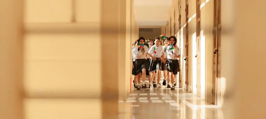 Một tiết học ở lại trong ảnh – Kỷ yếu lớp học và hành lang 1 Nhóm bạn cầm chong chóng đi qua hành lang có nắng