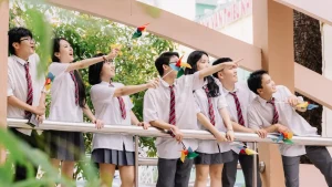 Nhóm bạn cầm chong chóng nhiều màu bên lan can trường