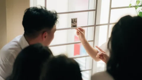 Đứng lại chỗ ngày xưa – Chụp lại ảnh kỷ yếu khi họp lớp 7 Hai học sinh xem ảnh in bên cửa sổ