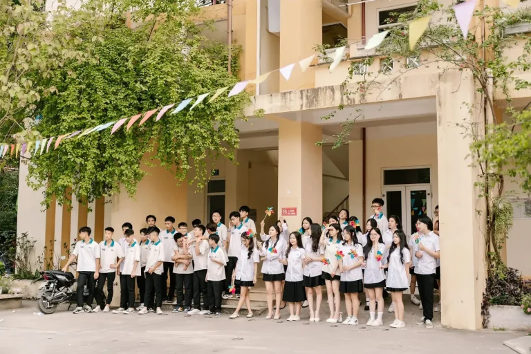 Tập thể lớp và thầy cô chụp ảnh trước dãy phòng học
