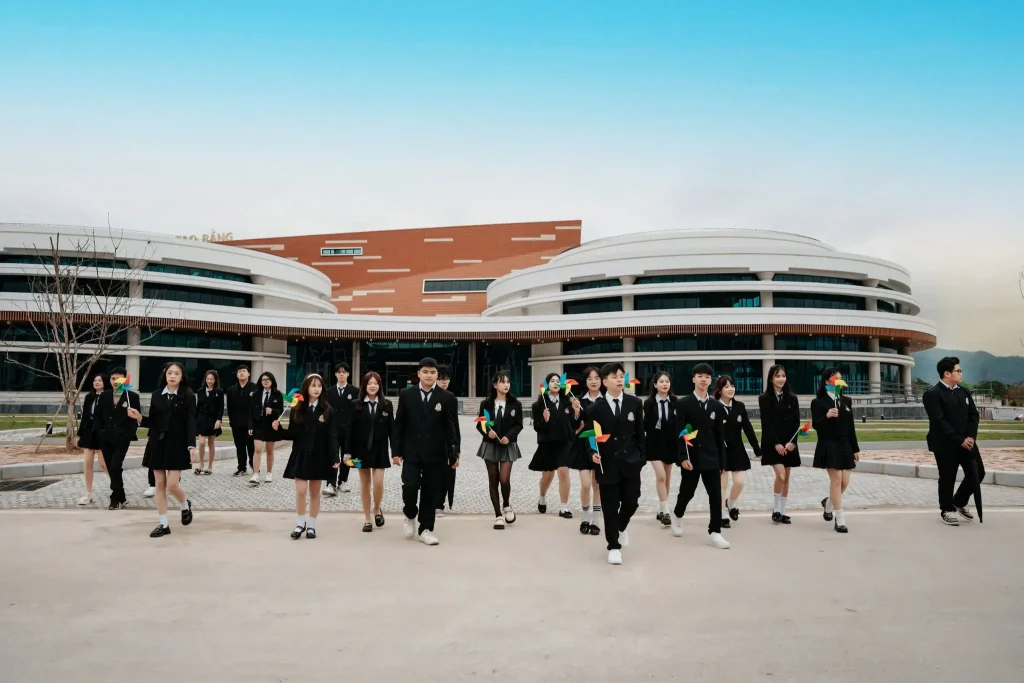Học sinh mặc đồng phục chụp tập thể trước tòa nhà lớn