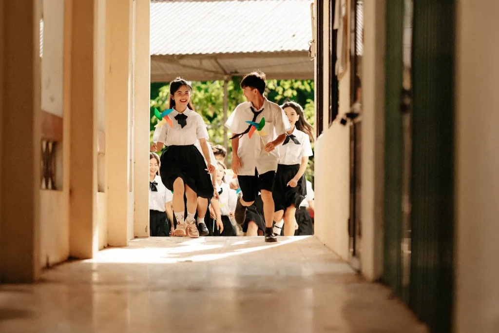 Nhóm học sinh nhìn qua cửa lớp ra hành lang