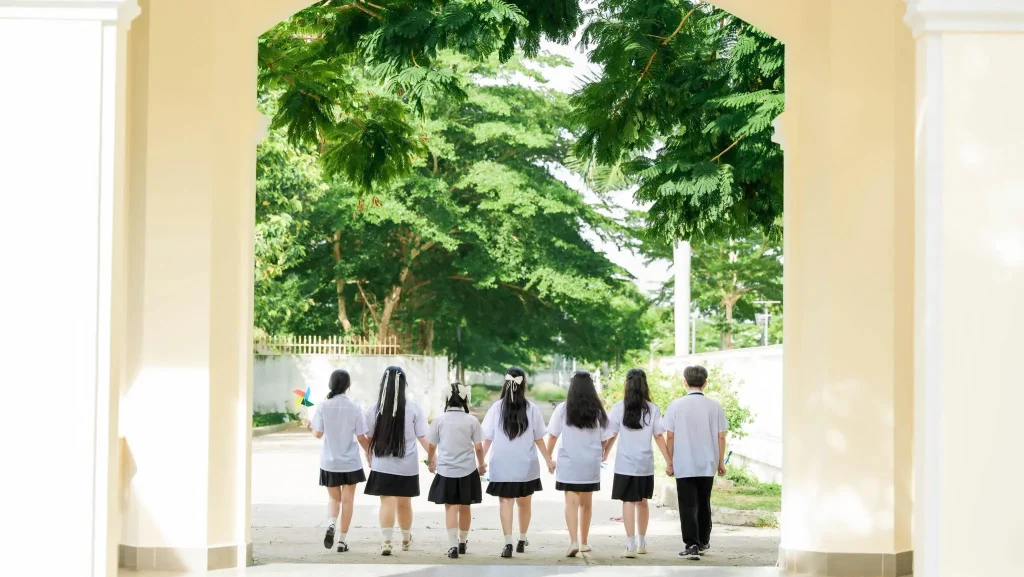 Nhóm học sinh nhìn ra sân từ hành lang