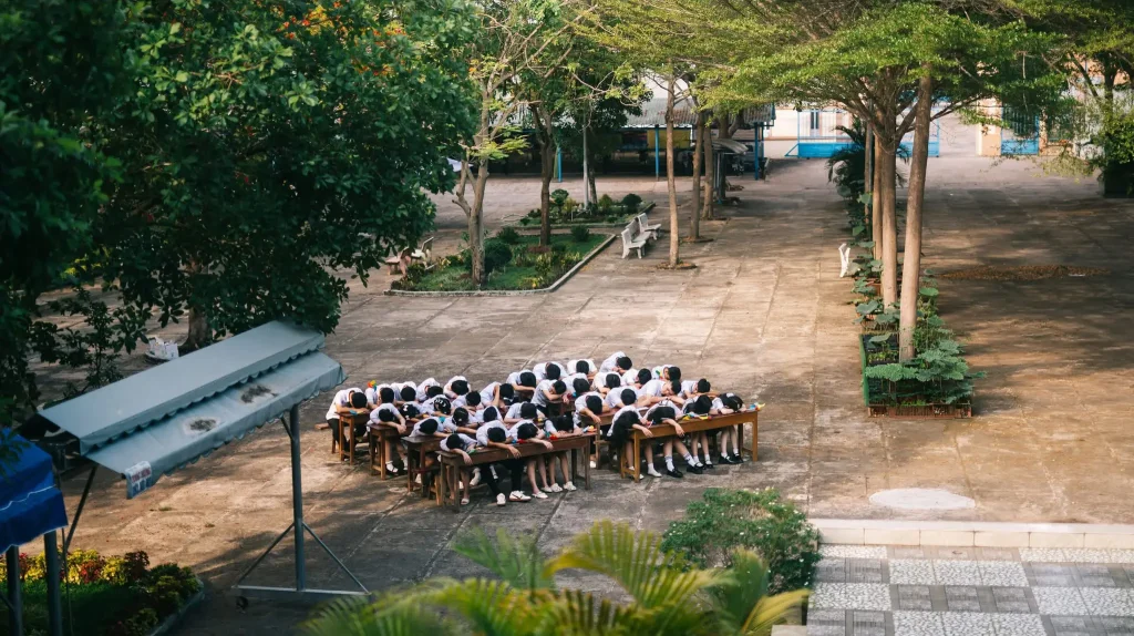 Tập thể học sinh xếp nhóm trên sân trường nhìn từ trên cao
