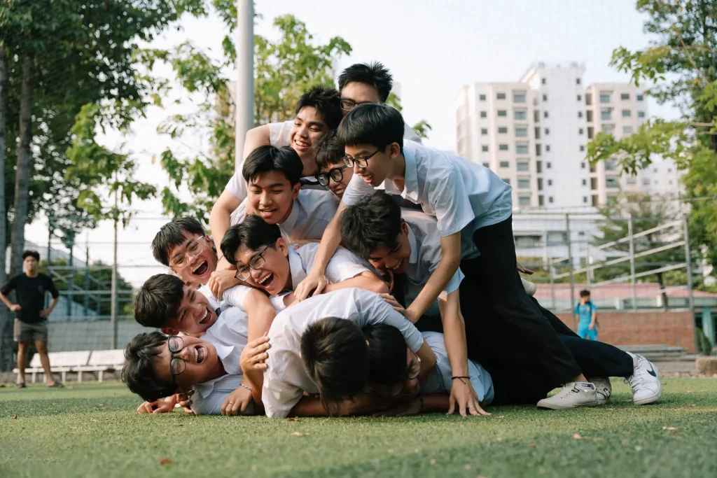 Nhóm bạn nam mặc đồng phục tạo dáng trên bãi cỏ
