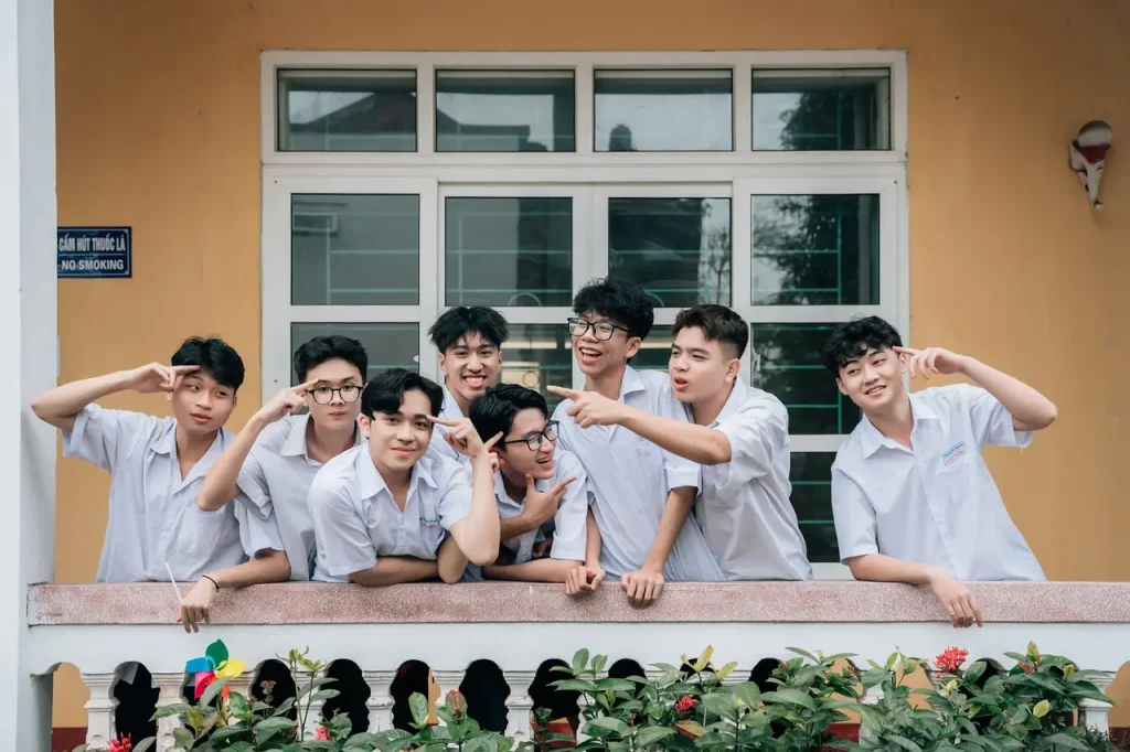 Nam sinh bên bức tường thấp với chong chóng
