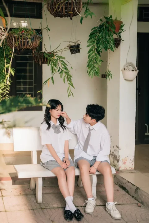 Nhóm bạn ngồi gần cửa sổ lớp học và cây xanh