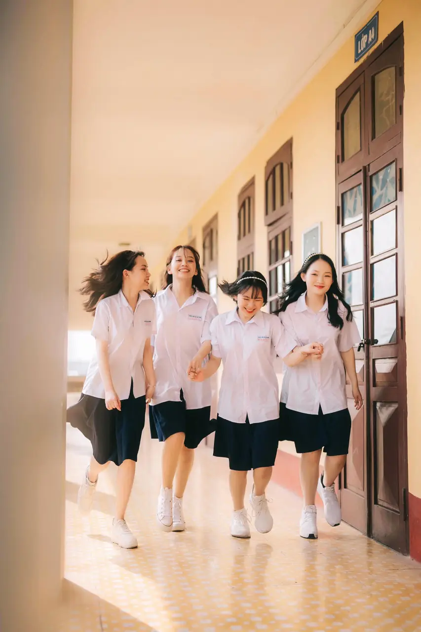 Nhóm học sinh đi về phía máy ảnh trong hành lang