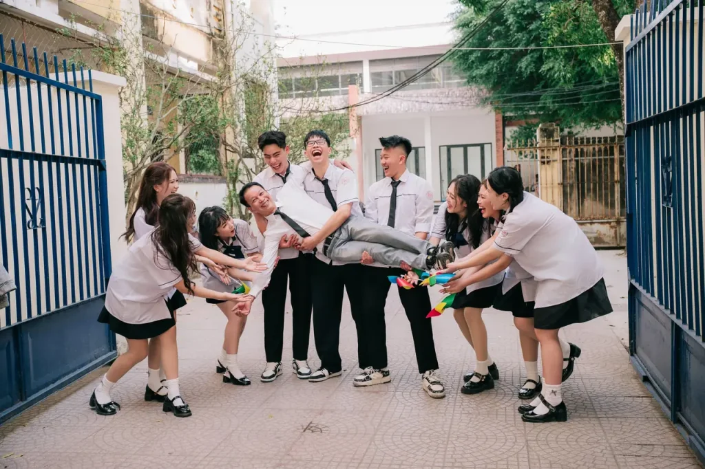 Nhóm học sinh tạo dáng vui trước cổng xanh