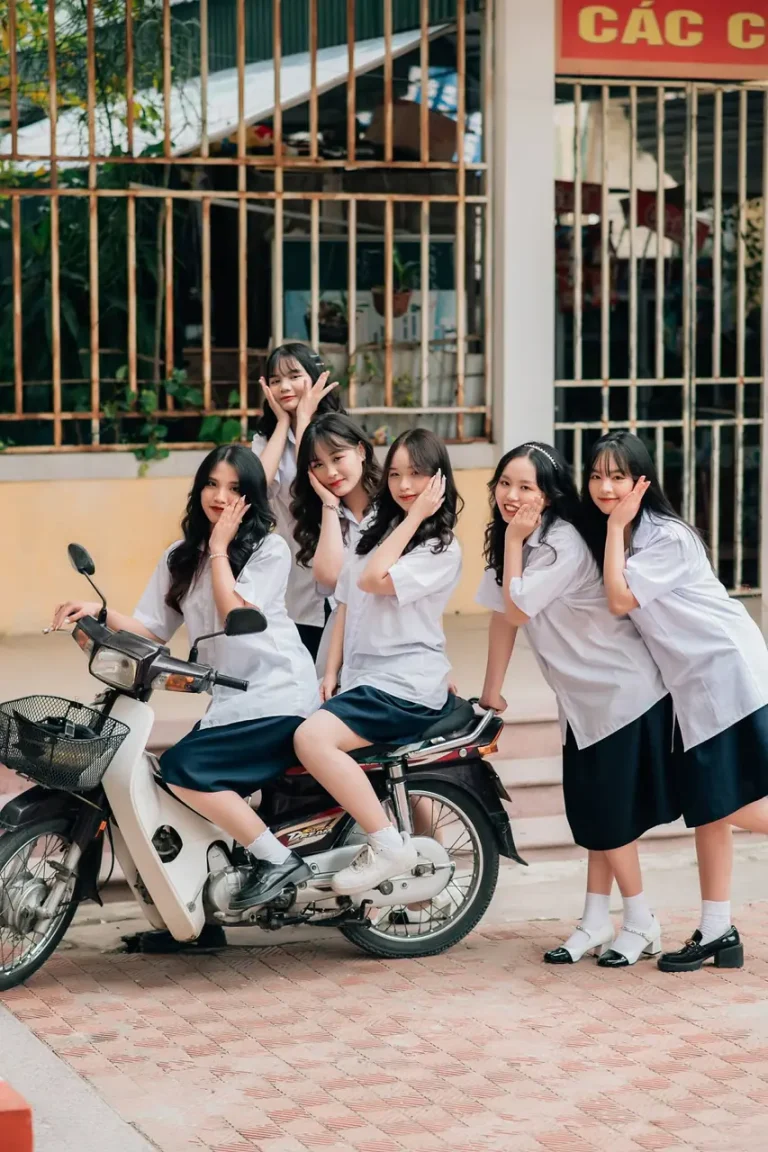 Nữ sinh bên xe máy trắng trong sân trường