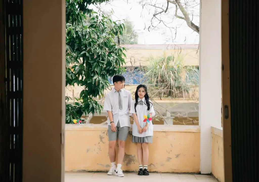 Nữ sinh mặc đồng phục bên cửa sổ hành lang