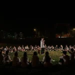 Cả lớp ngồi thành vòng tròn trên sân cỏ vào buổi tối