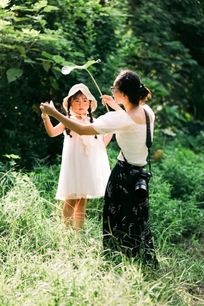 Bé và người thân cùng chơi ngoài trời dưới tán cây