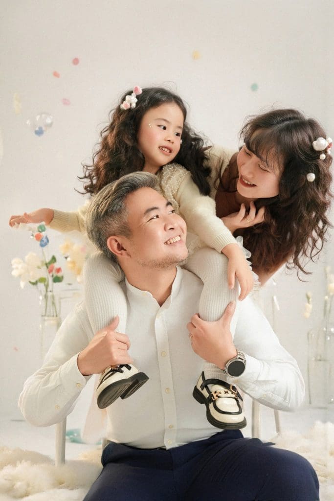 Gia đình có hai bé tương tác với nhau trong trang phục tông sáng
