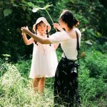Bé và người thân cùng chơi ngoài trời dưới tán cây