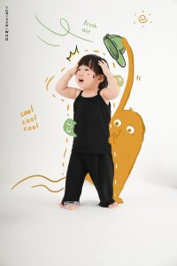 Bé trai mặc đồ đen đứng trước bối cảnh minh họa con vật