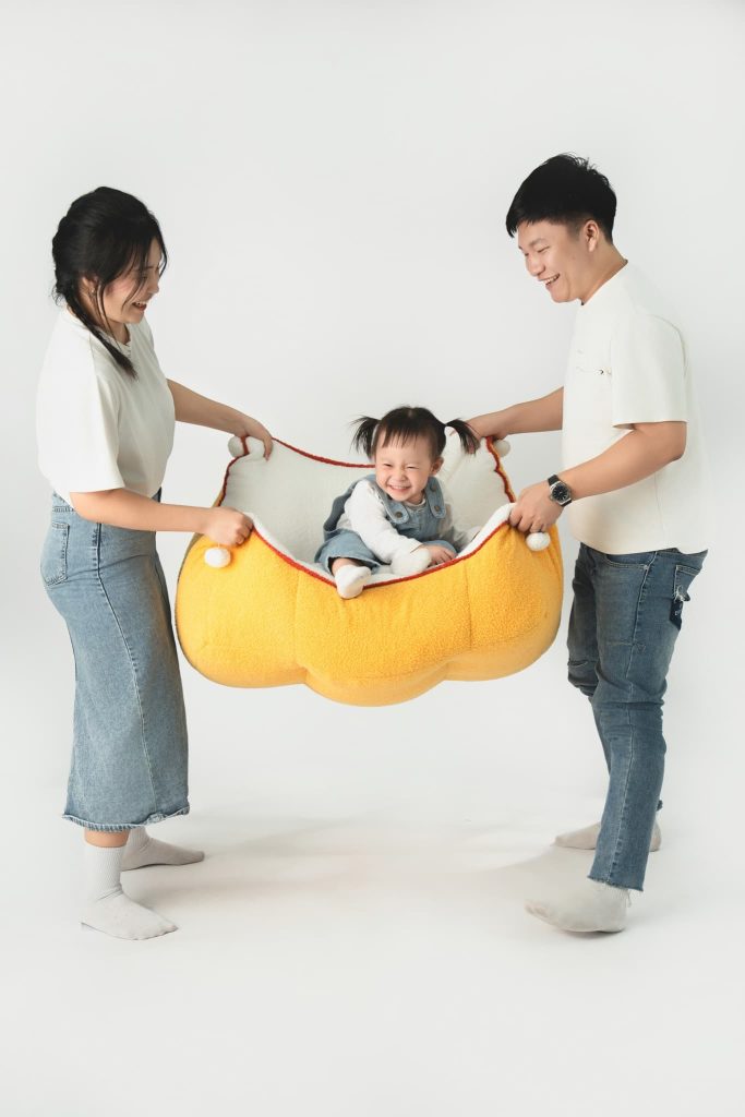 Ba mẹ tương tác với bé và đạo cụ màu vàng trên nền sáng