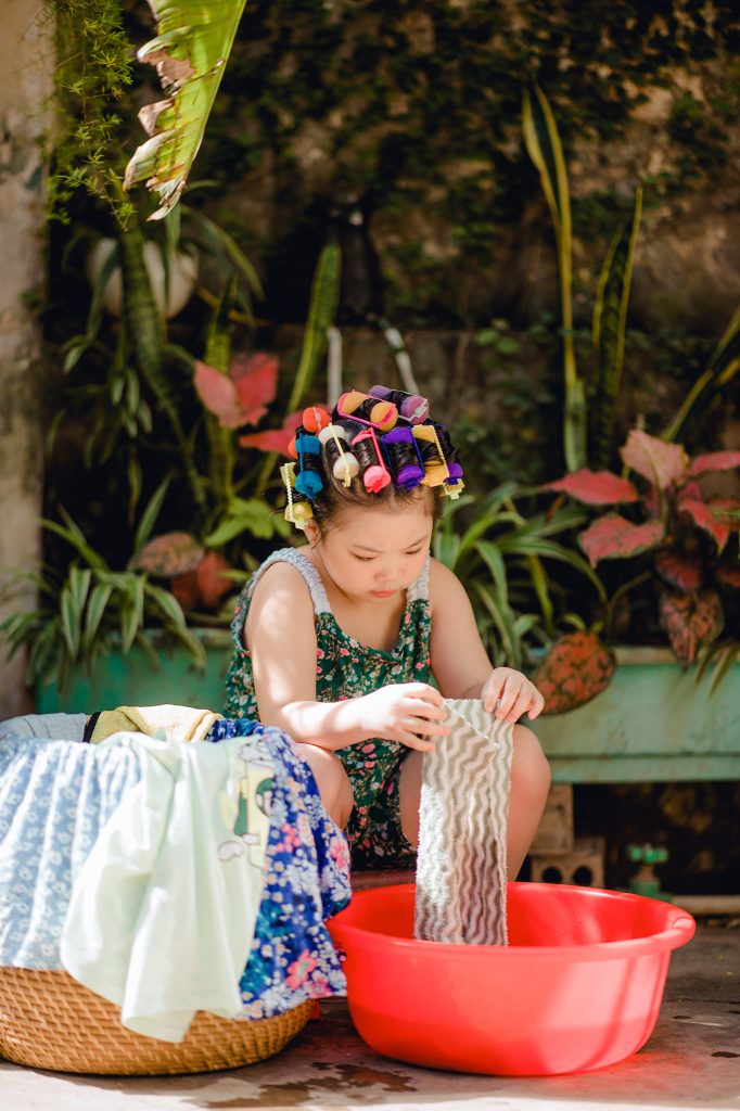 Bé giặt khăn trên bàn giặt nhỏ
