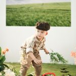 Bé trai cầm bình tưới trong bối cảnh khu vườn