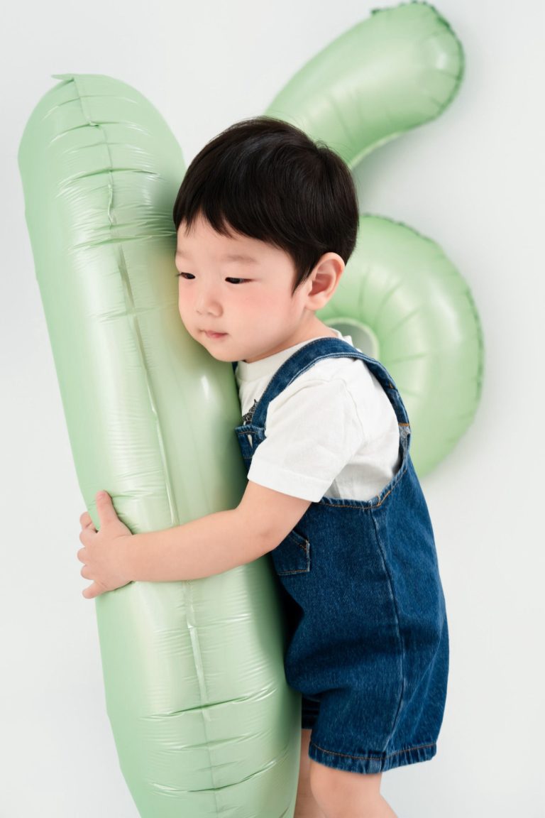 Bé mặc yếm xanh ôm bóng số màu xanh nhạt trên nền sáng