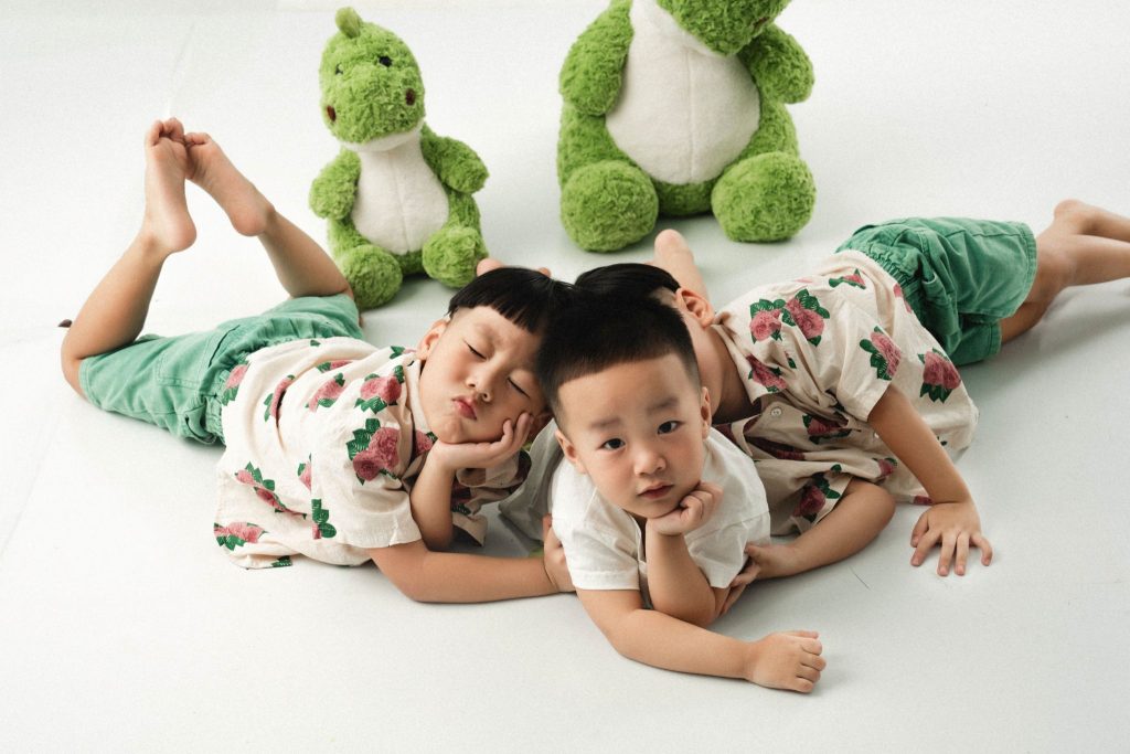 Ba bé nằm sấp, tựa cằm gần những cánh tay