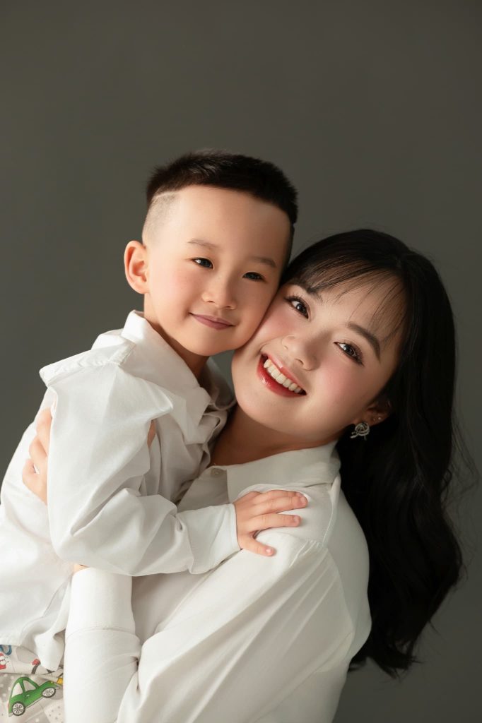 Mẹ và bé tựa vào nhau trong bộ ảnh gia đình nền tối