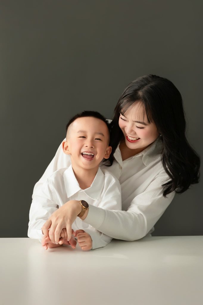 Mẹ và bé cười bên nhau trên nền tối