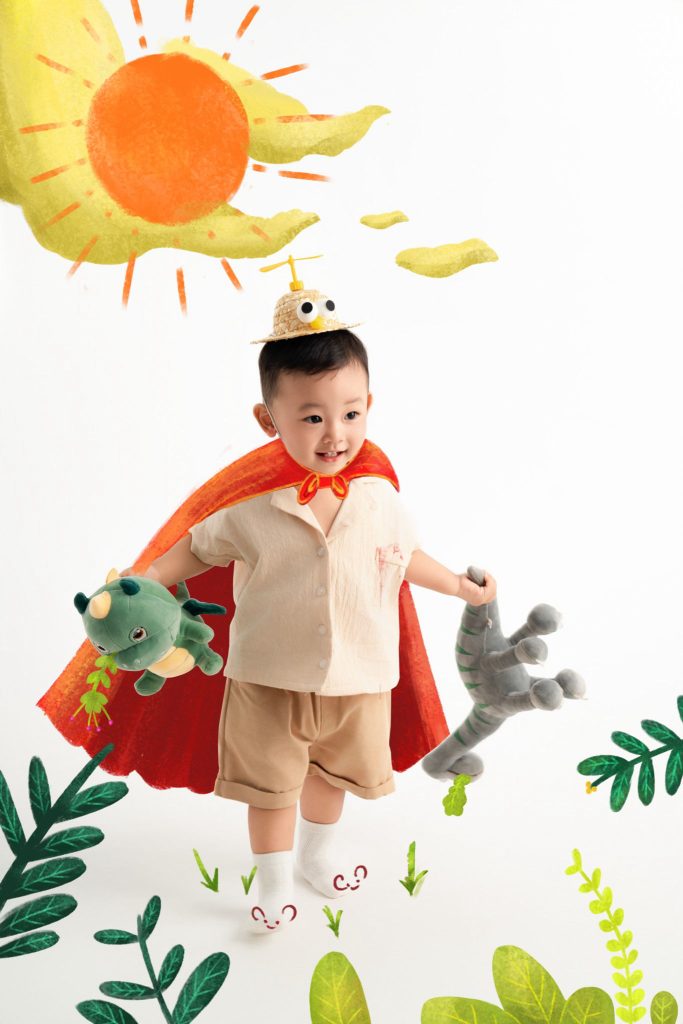 Bé đưa tay phía trước dưới hình mặt trời và chiếc lá