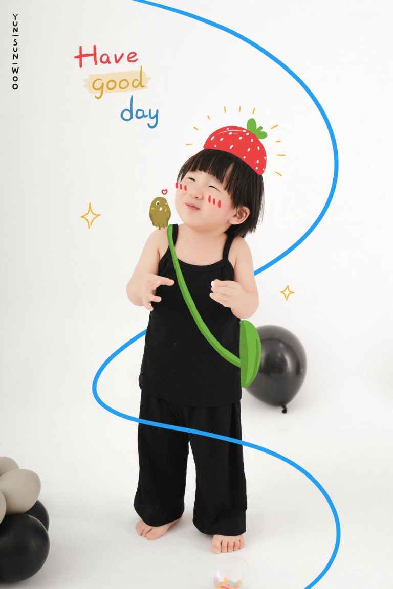 Bé nhắm mắt đặt tay lên má, đội mũ len đỏ