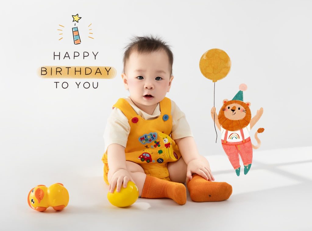 Bé mặc đồ vàng ngồi cùng quả cam trong ảnh thôi nôi