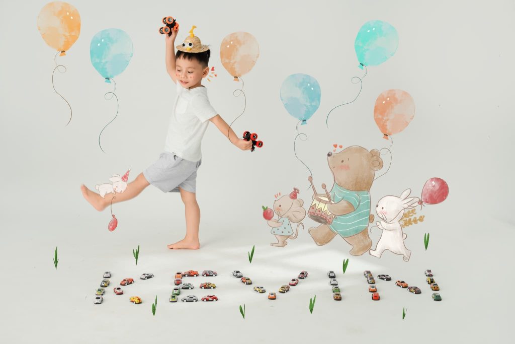 Bé đội vương miện trong bối cảnh sinh nhật với bóng màu và hình gấu