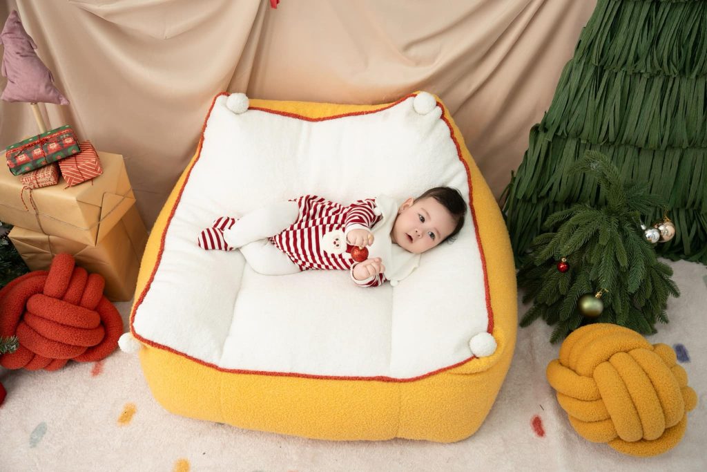 Ảnh từ trên xuống bé nằm ngửa trên chiếc giường vàng
